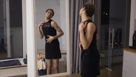 A-man-in-little-black-dress-in-front-the-mirror-sensually-moves