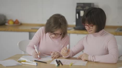 Portrait-of-two-girls-draw-with-colorful-pens-at-home