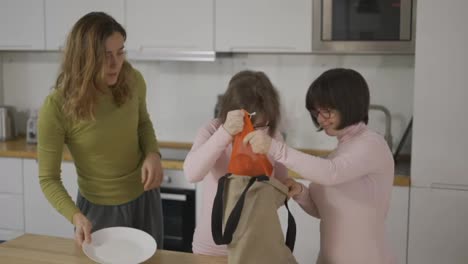 Down-syndrome-girls-with-mother-on-kitchen-with-groceries