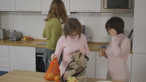 Down-syndrome-girls-with-mother-on-kitchen-after-shopping