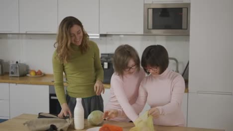 Down-syndrome-girls-with-mother-on-kitchen-after-shopping,-slow-motion