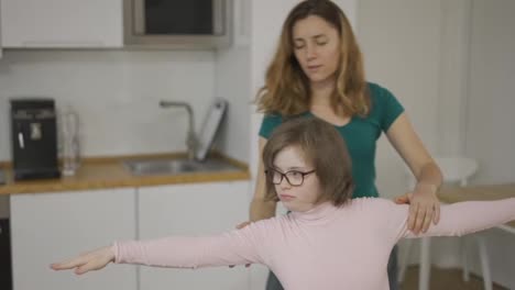 Girl-with-down-syndrome-and-her-mom-practicing-yoga-position-at-home