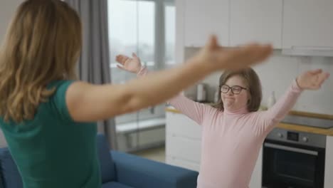Girl-with-down-syndrome-and-her-mom-practicing-yoga-position-at-home,-tree-position