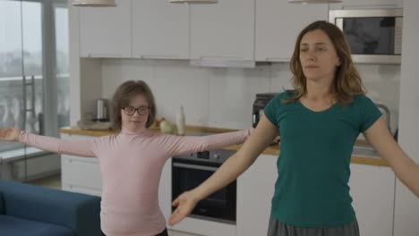Positive-Reife-Frau-Mit-Behinderter-Tochter,-Die-Zu-Hause-Yoga-Praktiziert