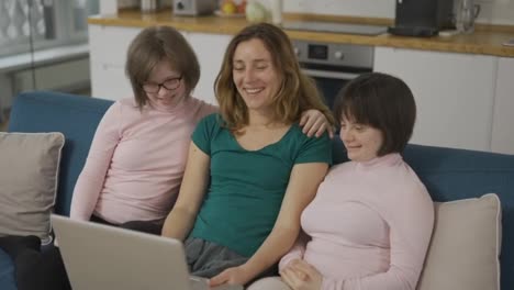 Mother-with-two-daughters-down-syndrome-making-video-call-using-laptop