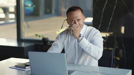 Smiling-businessman-working-on-laptop-computer-at-office.-Male-professional-typing-on-laptop-keyboard-at-office-workplace