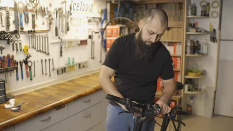 Master-adjusts-tilt-of-bike's-steering-wheel-at-repair-service
