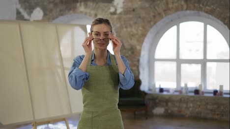 Portrait-of-a-woman-put-on-glasses-to-start-painting-in-workshop