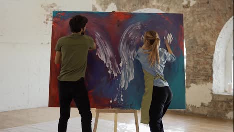Passionate-couple-holding-smear-colorful-paints-on-canvas,-create-picture-together