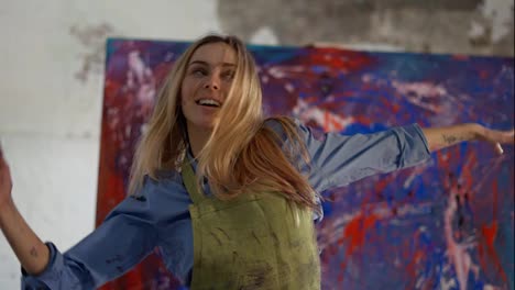 Woman-funny-dancing-in-front-of-abstract-painting-in-studio-in-slowmo