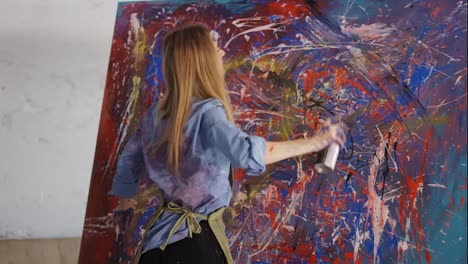 Passionate-woman-drawing-abstact-picture-using-spraying-paints-in-art-studio