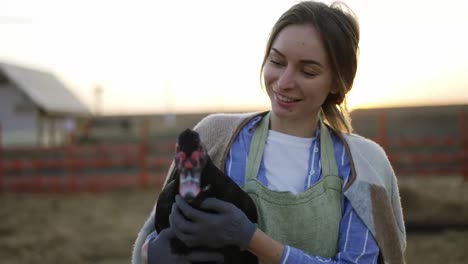Young-woman-holding-a-domestic-duck-on-a-local-farm