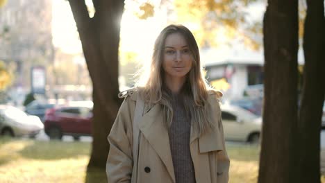 Blonde-smiling-woman-outdoors-in-lens-flares-in-autumn