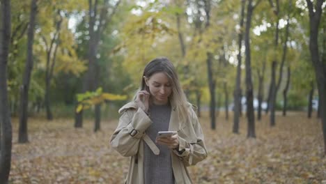 Junge-Schönheitsfrau,-Die-In-Einem-Herbstpark-Eine-Nachricht-Auf-Dem-Handy-Schreibt