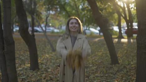 Happy-woman-throwing-leaves-in-autumn-in-slow-motion,-smiling