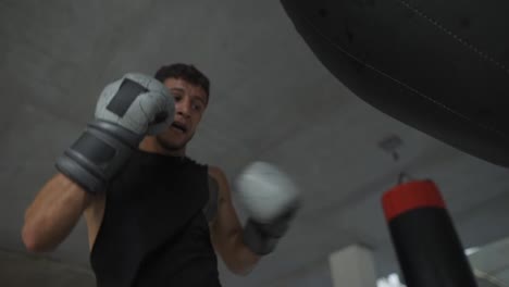 Männlicher-Boxer-Trainiert-Aggressiv-Mit-Boxsack