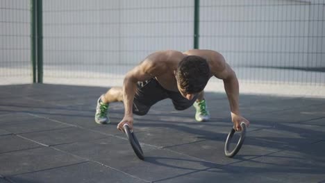 Strong,-muscular-man-is-doing-push-ups-by-rings