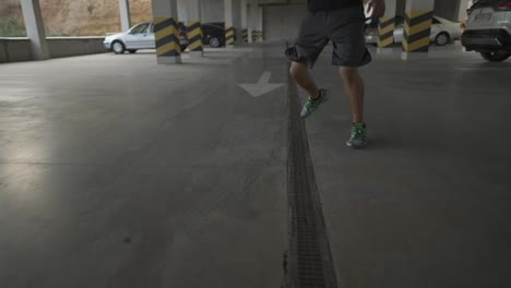Athlete-in-sportswear-warms-up-on-a-city-parking-garage,-cropped-footage