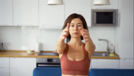 Mujer-Torciendo-Los-Brazos,-Practicando-Yoga-En-Casa,-Vista-Frontal
