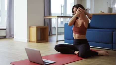 Frau-Praktiziert-Yoga-Mit-Trainer-Per-Videokonferenz-Und-Wärmt-Gelenke-Auf