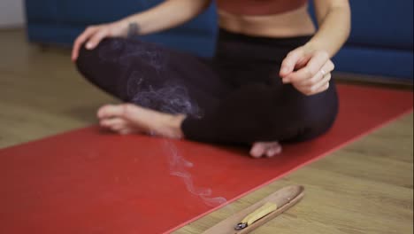Woman-meditating-with-burned-incense-herbs-and-incense,-cropped-view