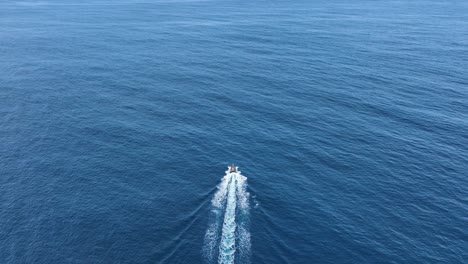 Motorboat-piloted-out-to-open-ocean-leaving-white-wake,-whale-watching-Azores