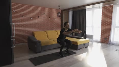Young-man-doing-squats-and-exercising-at-home