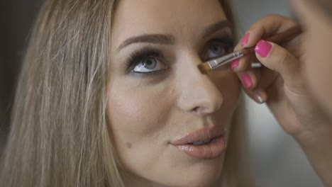 Makeup-artist-contouring-model's-nose-using-a-brush
