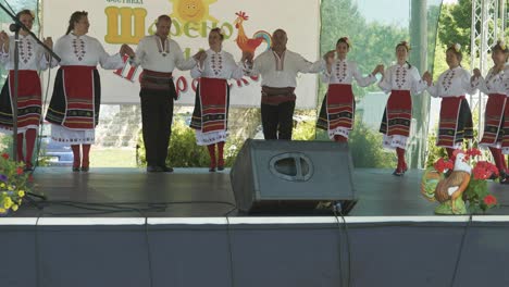Dance-group-in-traditional-costume-perform-horo-on-stage-at-cultural-event