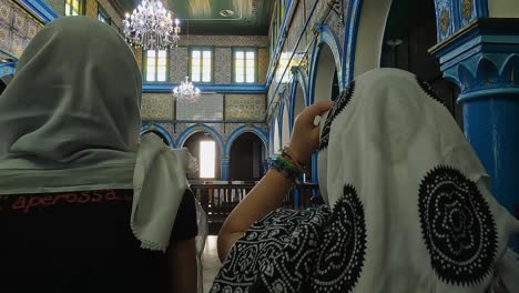 Back-view-of-female-tourist-admiring-beauty-of-El-Ghriba-Jewish-synagogue-of-Djerba-in-Tunisia