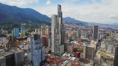 Tall-Modern-Tower-Buildings-Surrounded-By-Shorter-Downtown-Buildings-With-Mountain-Range-In-The-Background