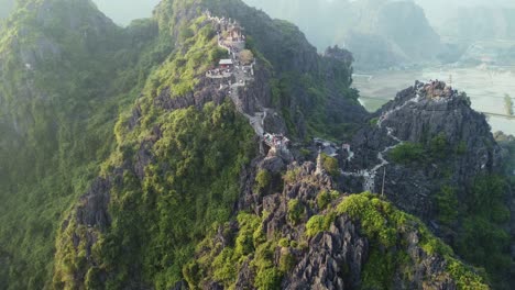 Aerial-Drone-Circling-Around-a-Big-Limestone-Mountain-with-A-Dragon-Temple-in-Vietnam