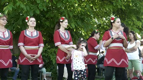 Kleines-Mädchen-Mit-Mutter-In-Traditioneller-Kleidung-Sieht-Beim-Tanzfestival-Gelangweilt-Aus