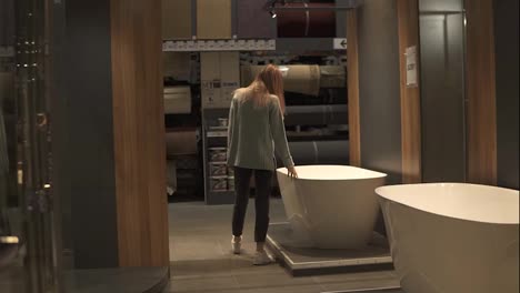 Woman-chooses-a-new-bath-in-an-interior-design-store