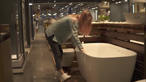 Woman-chooses-and-touch-new-bath-in-an-interior-design-store