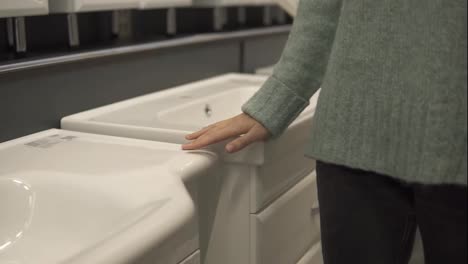 Woman-is-choosing-a-new-ceramic-sink-in-a-store