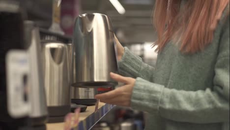 Woman-in-shop-of-home-appliances,-choosing-electric-tea-kettle
