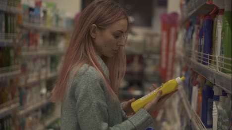 Woman-reads-label-of-household-products-in-supermarket