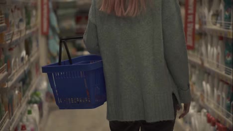 Rare-view-of-a-woman-walking-by-supermarket-with-basket