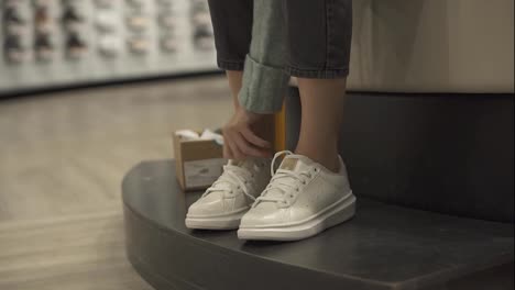 Woman-is-trying-new-white-sneakers-in-shoe-store