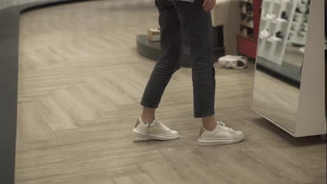 Woman-fits-new-white-sneakers-in-shoe-store,-trying-best-size