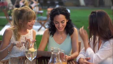 Three-beautiful-women-having-fun-choosing-meal,-looking-at-the-menu,-laughing-and-gesturing