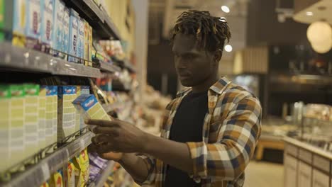 Stylish-african-american-guy-chooses-products-in-the-grocery-store