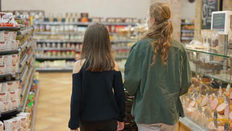 Una-Adolescente-Y-Su-Madre-Comprando-En-El-Supermercado,-Vista-Trasera
