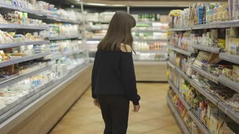 Cheerful-teenager-in-the-supermarket,-taking-sweets-from-the-shelf