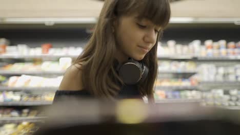 Close-up-footage-of-a-girl-in-the-store-taking-product-from-the-shelf