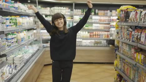 Adolescente-Feliz-En-El-Supermercado-Bailando-Con-Auriculares