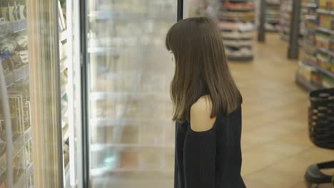 Hübscher-Teenager-Im-Supermarkt,-öffnet-Die-Tür-Des-Gefrierschranks-Und-Nimmt-Sich-Ein-Eis