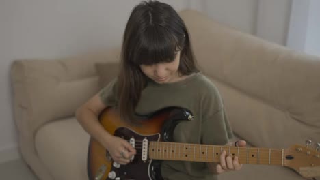 Teen-girl-learns-to-play-the-guitar