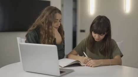 Teen-student-girl-has-individual-lesson-from-young-woman-teacher-with-laptop